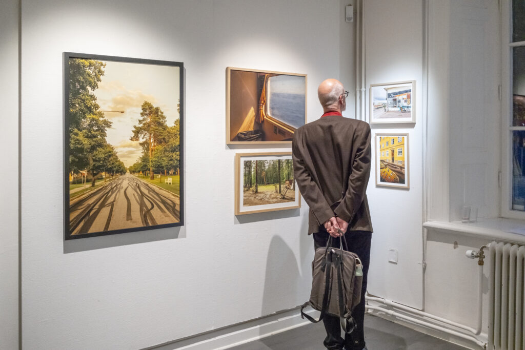 Besökare ser Gustav Grälls färgfotografier i utställningen Sverige på Härnösands Konsthall